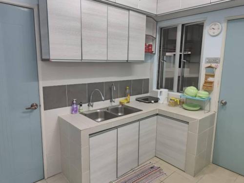 eine Küche mit weißen Schränken und einem Waschbecken in der Unterkunft FZHomestays In CH in Cameron Highlands