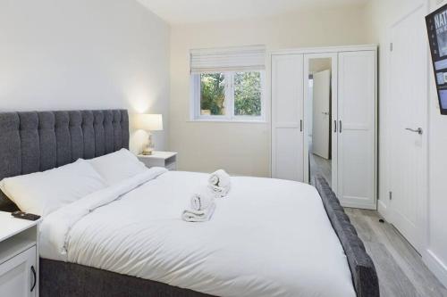 a bedroom with a large white bed with a window at The Grange Sleeps 8 Family Retreat Free Wi-Fi & Parking in Cheltenham