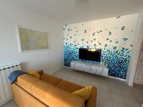 sala de estar con sofá y pared cubierta de confeti en Ca'Vio Beach & Pool, en Cavallino-Treporti
