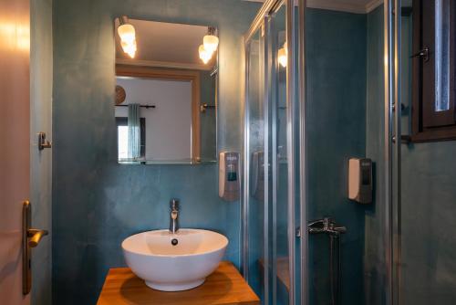 a bathroom with a white sink and a shower at Anemos Inn by Estia in Kokkíni Khánion