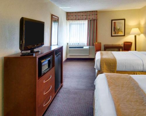 a hotel room with two beds and a flat screen tv at Quality Inn Jessup - Columbia South Near Fort Meade in Jessup