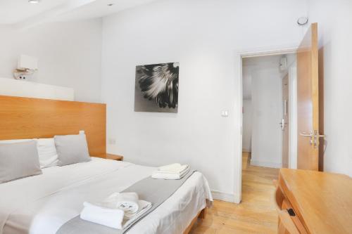 a bedroom with a large white bed with towels on it at BeiRoom Hyde Park Apartments in London