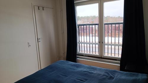a bedroom with a bed and a large window at Cozy-Mozy in Stockholm