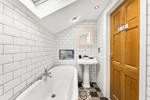 La salle de bains est pourvue d'une baignoire et d'un lavabo. dans l'établissement Remarkable Penthouse - Sea Views, à Worthing