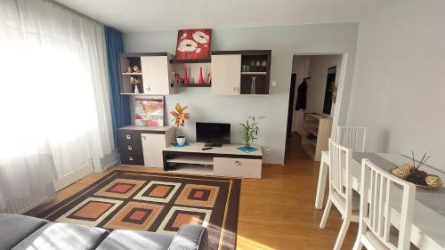 ein Wohnzimmer mit einem Sofa und einem Schreibtisch mit einem Computer in der Unterkunft Interex Apartment in Sibiu
