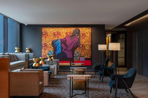 a lobby with a painting of a woman on the wall at Radisson RED Hotel Johannesburg Rosebank in Johannesburg