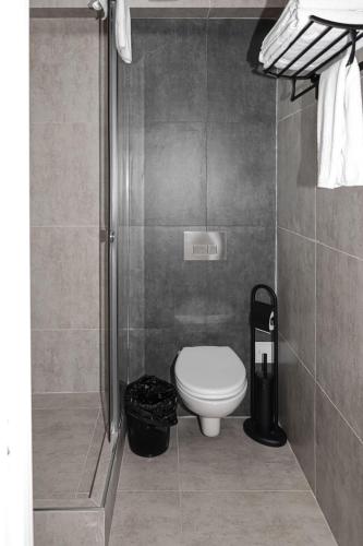 a small bathroom with a toilet and a shower at Deluxe Park Z hotel in Almaty