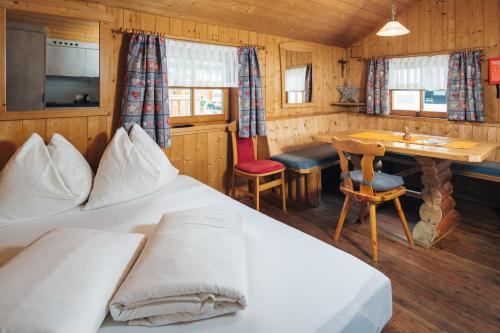 a bedroom with a bed and a desk and a table at kleine Blockhütte in Ried im Oberinntal