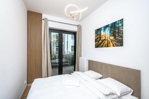a bedroom with a bed and a painting on the wall at RentPlanet - Apartament Kościuszki in Krakow