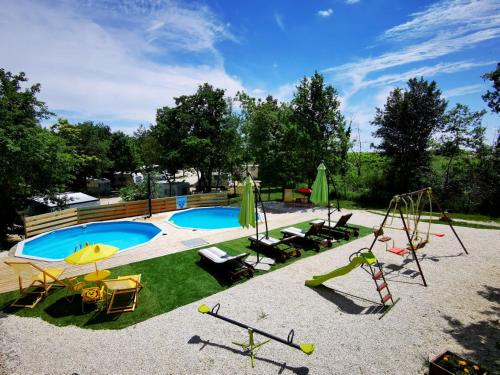 een achtertuin met een zwembad, schommels en een speeltuin bij Vita Mia in Pazin