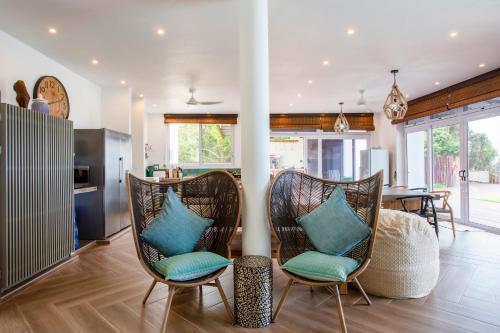 a living room with two chairs with blue pillows at Kangela 2 in Ponta Malongane