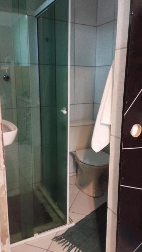 a bathroom with a glass shower and a toilet at Equilibra Soul in Caraguatatuba
