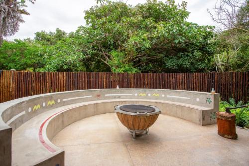a fire pit in a backyard with a fence at Kangela 2 in Ponta Malongane