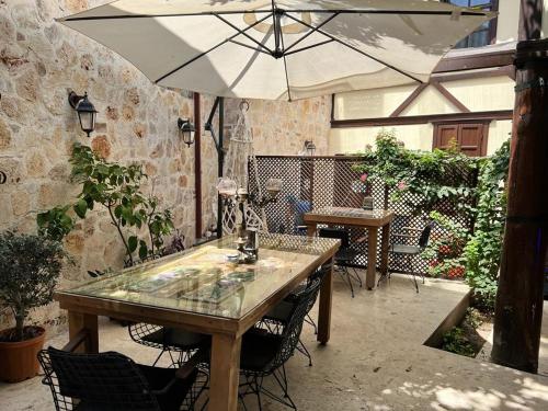 a table and chairs with an umbrella on a patio at Villa Citronella Boutique Hotel in Antalya