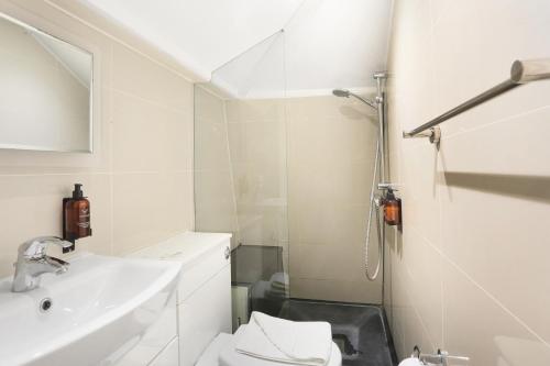 a white bathroom with a toilet and a sink at BeiRoom Hyde Park Apartments in London