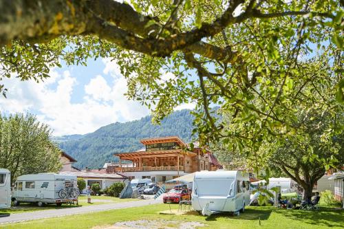 a couple of rvs parked in front of a building at Wohnfass mitte in Ried im Oberinntal