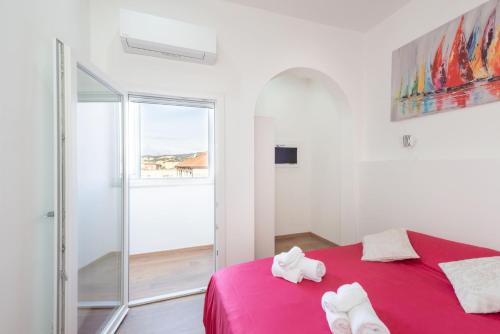 - une chambre avec un lit rose et une fenêtre dans l'établissement Piombino Apartments - Casa Chiassatello, à Piombino
