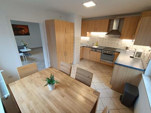 eine Küche und ein Esszimmer mit einem Holztisch und Stühlen in der Unterkunft Geräumige helle Wohnung im grünen Taunus mit Privatparkplatz in Schlangenbad