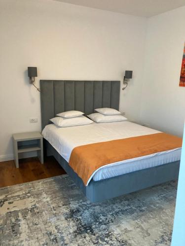 a bedroom with a large bed with a gray headboard at Pensiunea Magic in Băile Govora