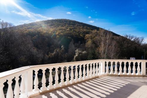 a white fence with a mountain in the background at Youtopia Riverside in Stara Zagora