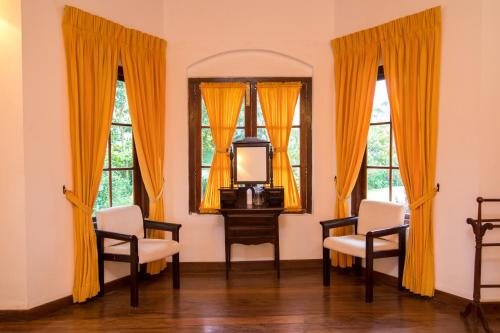 a living room with two chairs and a mirror at Iona Bungalow by Lalan Leisure in Hatton