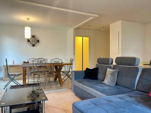 un salon avec un canapé et une table dans l'établissement L'appartement Michelet - Parking privé et gratuit - 2km Cité Médiévale, à Carcassonne