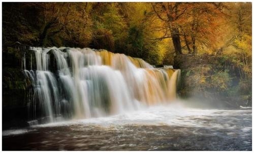 a waterfall in the middle of a river at James' Place @ Pontmorlais in Merthyr Tydfil