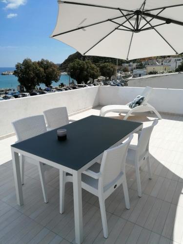 uma mesa e cadeiras numa varanda com um guarda-sol em Pavlos Apartment em Kalyves