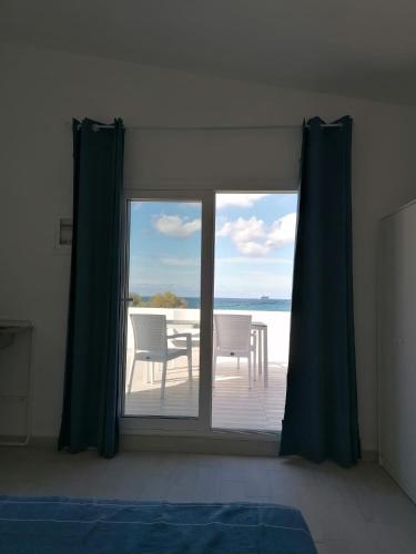 um quarto com uma janela com vista para o oceano em Pavlos Apartment em Kalyves