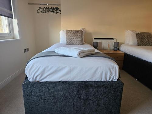 a bedroom with a large bed with a ottoman at Town center modern apartment 10 in Ipswich