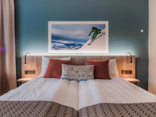 una cama con una foto de una persona montando una tabla de snowboard en Nordfjord Hotell - Bryggen, en Nordfjordeid