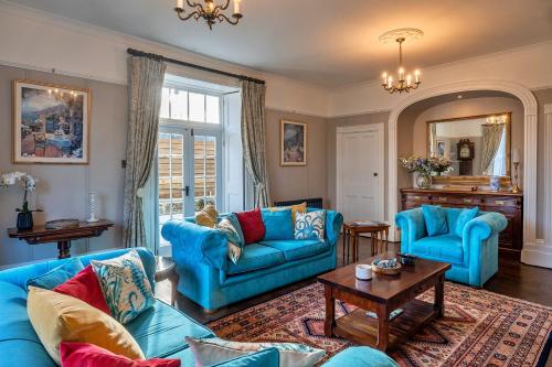 un soggiorno con divani blu e un tavolo di Finest Retreats - The Old Counting House a Gweek