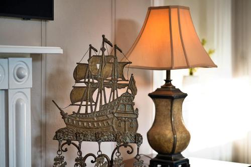 a wooden ship on a table next to a lamp at Finest Retreats - The Old Counting House in Gweek