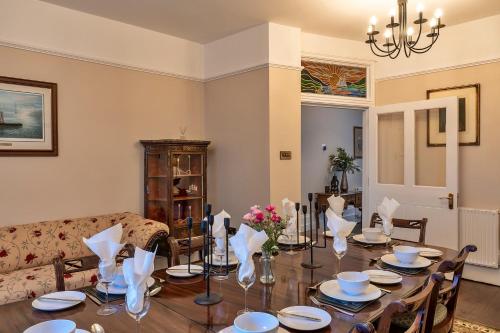 a dining room with a table and a couch at Finest Retreats - The Old Counting House in Gweek