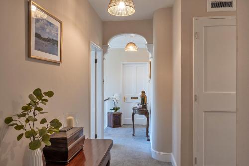 a hallway with a door and a table and a desk at Finest Retreats - The Old Counting House in Gweek