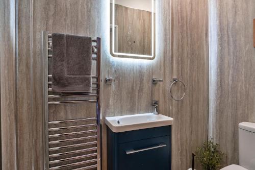 a bathroom with a sink and a mirror at Finest Retreats - The Old Counting House in Gweek