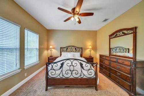 a bedroom with a bed and a mirror and a ceiling fan at 30A Getaway Too! in Santa Rosa Beach