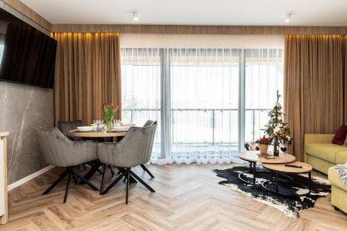 a living room with a table and a living room with a christmas tree at Domki przy Szlaku Pod Gubałówką in Zakopane