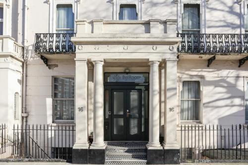 un edificio blanco con una puerta negra y escaleras en BeiRoom Hyde Park Apartments en Londres