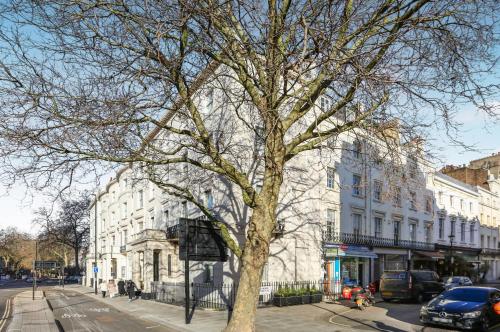 a tree on a city street next to a building at BeiRoom Hyde Park Apartments in London