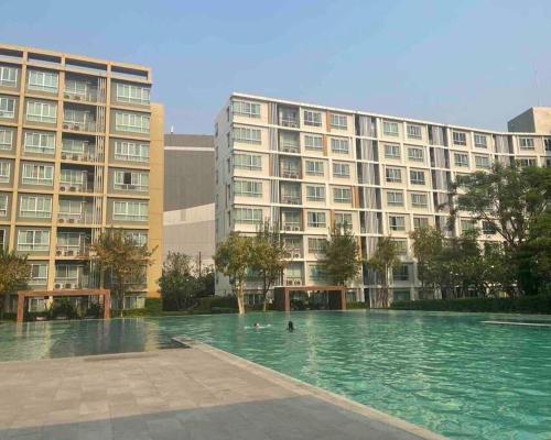 a swimming pool in front of a large building at D condo sign D3 in Chiang Mai