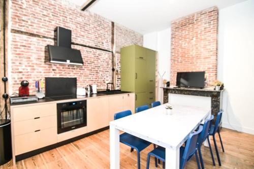 a kitchen with a white table and blue chairs at Comfortable room with terrace European Parliament in Brussels