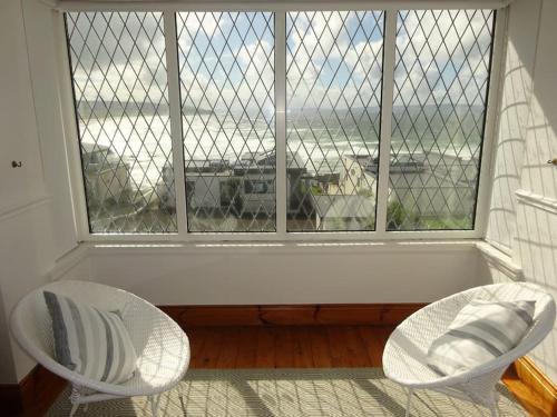 2 Stühle und ein Fenster mit Blick auf den Flughafen in der Unterkunft Portstewart Sea View Strand House in Portstewart