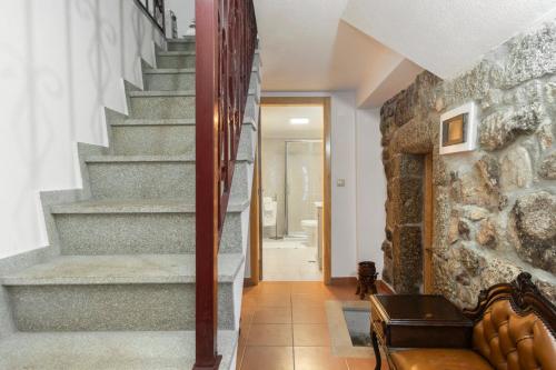 a staircase in a home with a stone wall at Rustic Getaway in Guarda in Gouveia