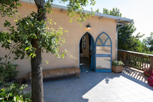 a house with a blue door and a bench at Rom Farm by Glow - חוות רום in Kammon
