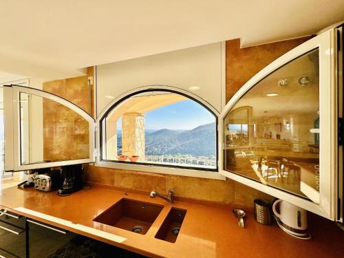 a kitchen with a sink and a large window at Aurea CostaBravaSi in Sant Feliu de Guíxols