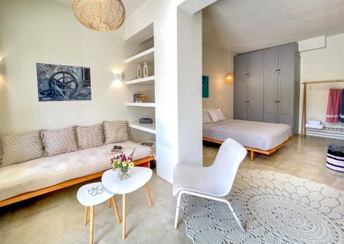 sypialnia z kanapą, łóżkiem i stołem w obiekcie Kynthia Suite - Escape to Seaside Makry Gialos w mieście Makry Gialos