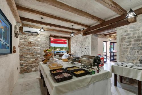 uma cozinha com uma mesa com comida em Hotel Timun em Gdinj