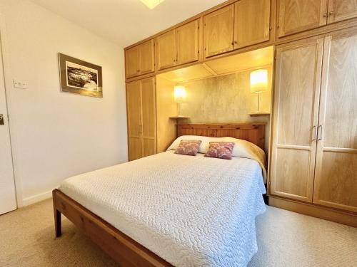 1 dormitorio con 1 cama y armarios de madera en New Tower House - At 10 pear tree court with parking, en York