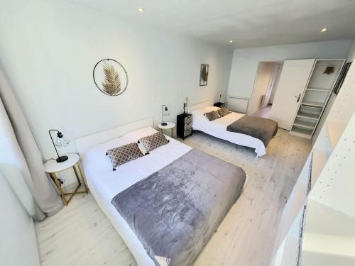 a large bedroom with two beds and a mirror at [LE REPOS] Maison 6 couchages avec jardin privé in Loubajas